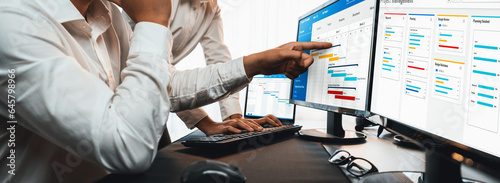 Project management team coordinating and update project planned schedule on computer using Gantt chart software in office. Business people planning time and deadline for company task. Trailblazing