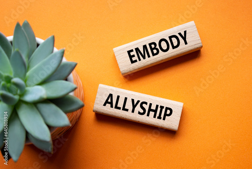 Embody Allyship symbol. Concept word Embody Allyship on wooden blocks. Beautiful orange background with succulent plant. Business and Embody Allyship concept. Copy space