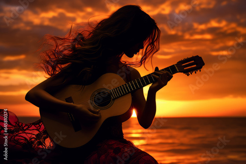 Silhouette of a beautiful woman playing the guitar at sunset