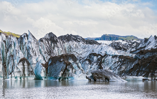 Obraz na płótnie Solheimajokull picturesque glacier in southern Iceland. The tongue of this glacier slides from the volcano Katla. Beautiful glacial lake lagoon with blocks of ice and surrounding mountains. w salonie