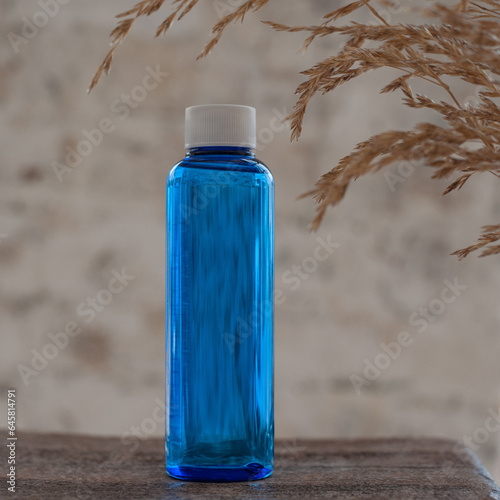 Photos blue tall jar for cosmetics on a wooden table decorated with dried flowers
