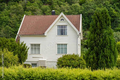 Traditional white wooden house with a heat pump.