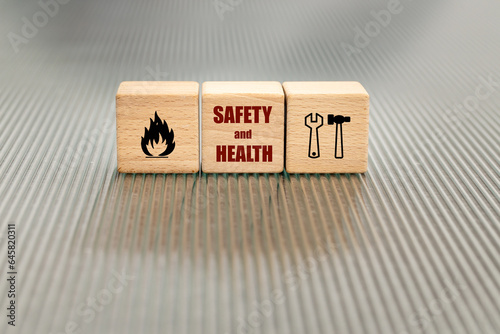 Obraz na płótnie Occupational health and safety, Concept of safety at work, accident insurance, wooden blocks with the text safety and health, icons of work tools, attention fire danger w salonie