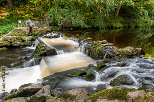 Long exposure of the river Teign flowing through Castle Drogo weir in Dartmoor