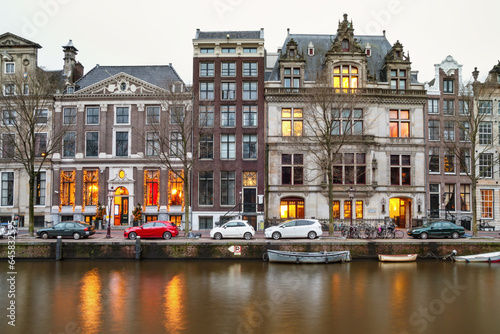 Obraz na płótnie Cityscape - evening view of the houses with festive decorations and the city channel with boats, city of Amsterdam, The Netherlands w salonie