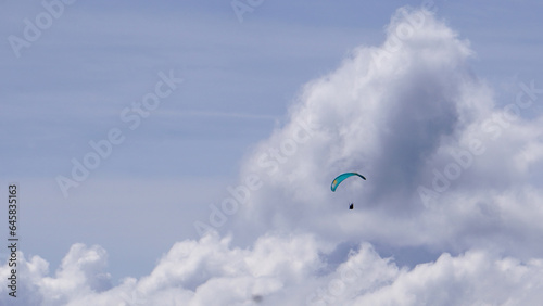 A paragliding flying in sky among clouds 