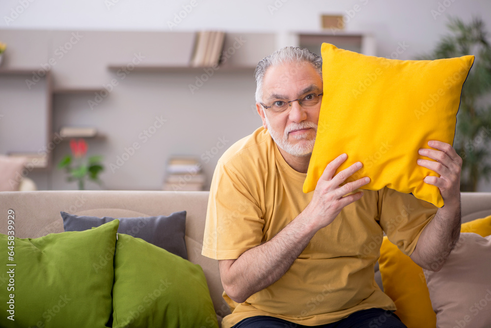 Old man with many pillows at home