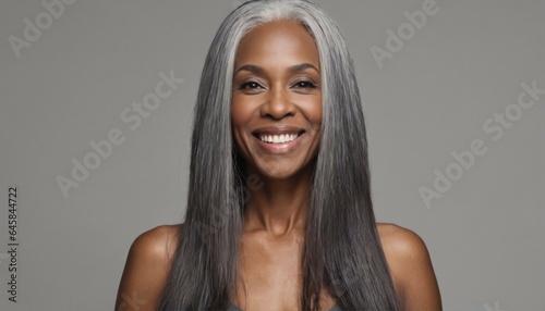 Gorgeous mature woman with long gray hair and smooth healthy skin smiling happily in beauty and cosmetics skincare advertising concept photo