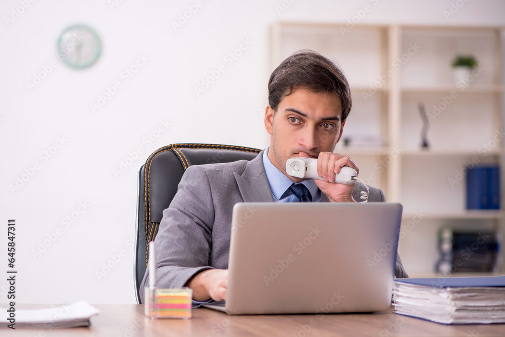 Young male employee working in the office Young male employee working in the office