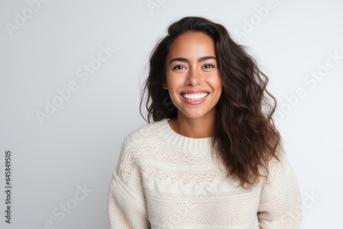Medium shot portrait photography of a Peruvian woman in her 30s wearing a cozy sweater against a white background