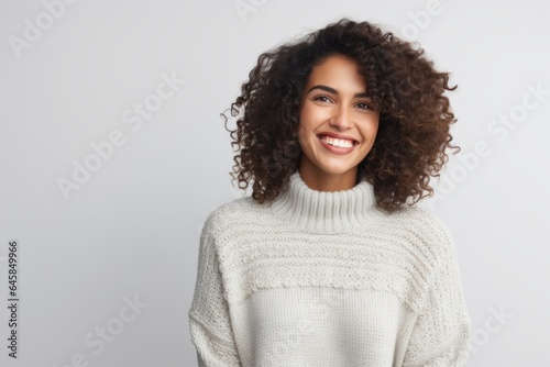 Portrait photography of a cheerful Colombian woman in her 30s wearing a cozy sweater against a white background