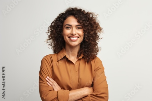 Portrait photography of a Colombian woman in her 30s wearing a smart pair of trousers against a white background