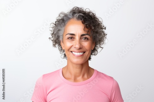 Portrait photography of a Colombian woman in her 50s wearing a sporty polo shirt against a white background