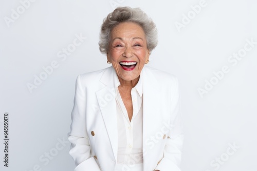 Portrait photography of a cheerful Colombian woman in her 90s wearing a sleek suit against a white background