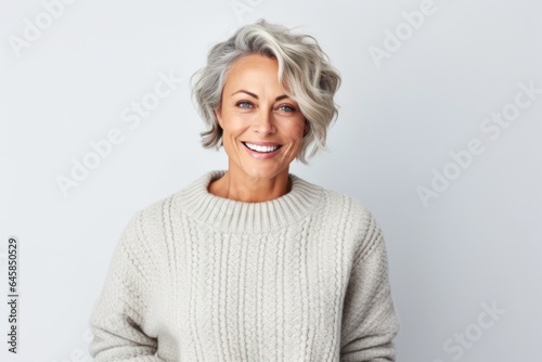 Medium shot portrait photography of a Swedish woman in her 50s wearing a cozy sweater against a white background