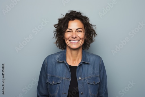 Close-up portrait photography of a Italian woman in her 40s wearing a denim jacket against a minimalist or empty room background