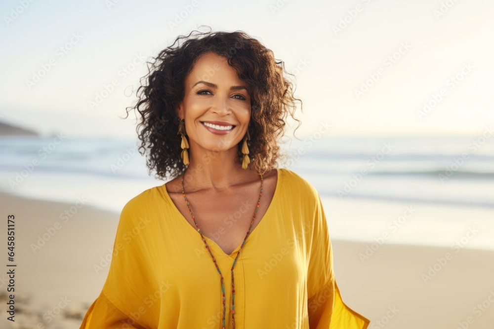 Medium shot portrait photography of a Colombian woman in her 50s wearing a simple tunic against a beach background Medium shot portrait photography of a Colombian woman in her 50s wearing a simple tunic against a beach background