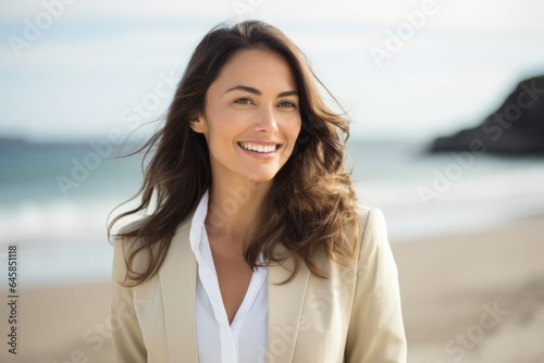 Portrait photography of a Colombian woman in her 30s wearing a classic blazer against a beach background
