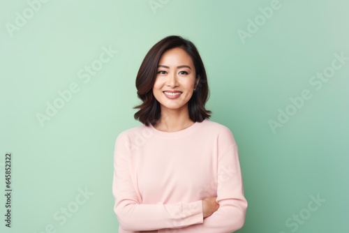 Portrait photography of a Vietnamese woman in her 30s against a pastel or soft colors background