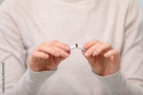 Stop smoking concept. Woman breaking cigarette  closeup