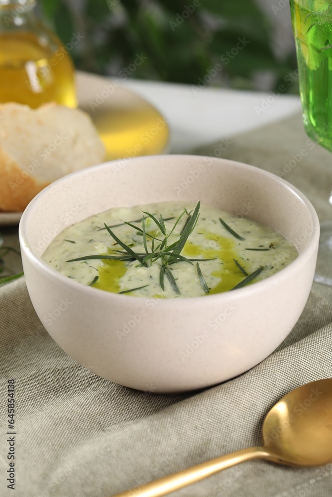 Delicious cream soup with tarragon, spices and potato in bowl on table Delicious cream soup with tarragon, spices and potato in bowl on table