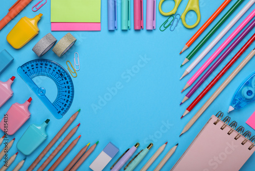 Back to school. Frame of different school stationery on light blue background, flat lay. Space for text