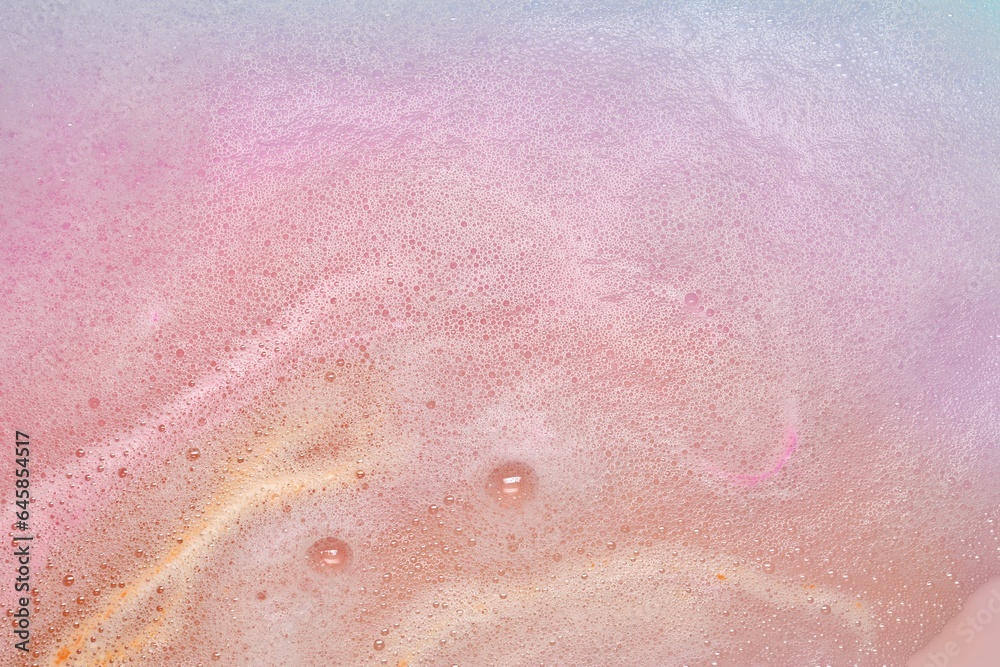 Colorful foam after dissolving bath bomb in water, closeup