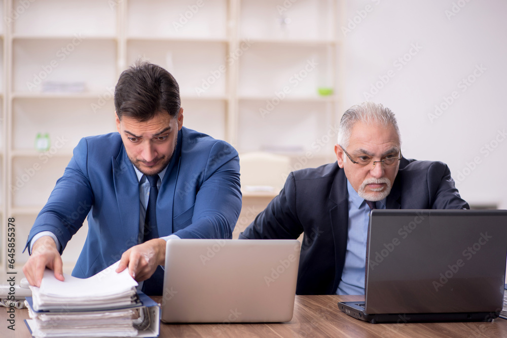 Two male employees working in the office Two male employees working in the office