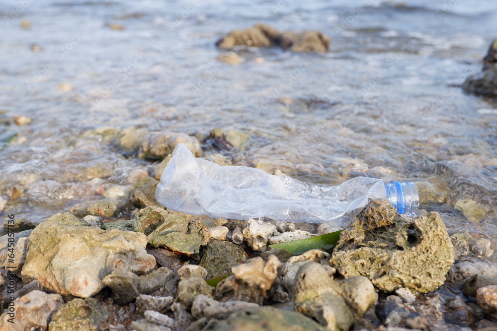 Obraz premium crashing sea waves carrying plastic drink bottle waste. the ecological concept of going green to reduce the use of plastic bottles which are difficult to recycle