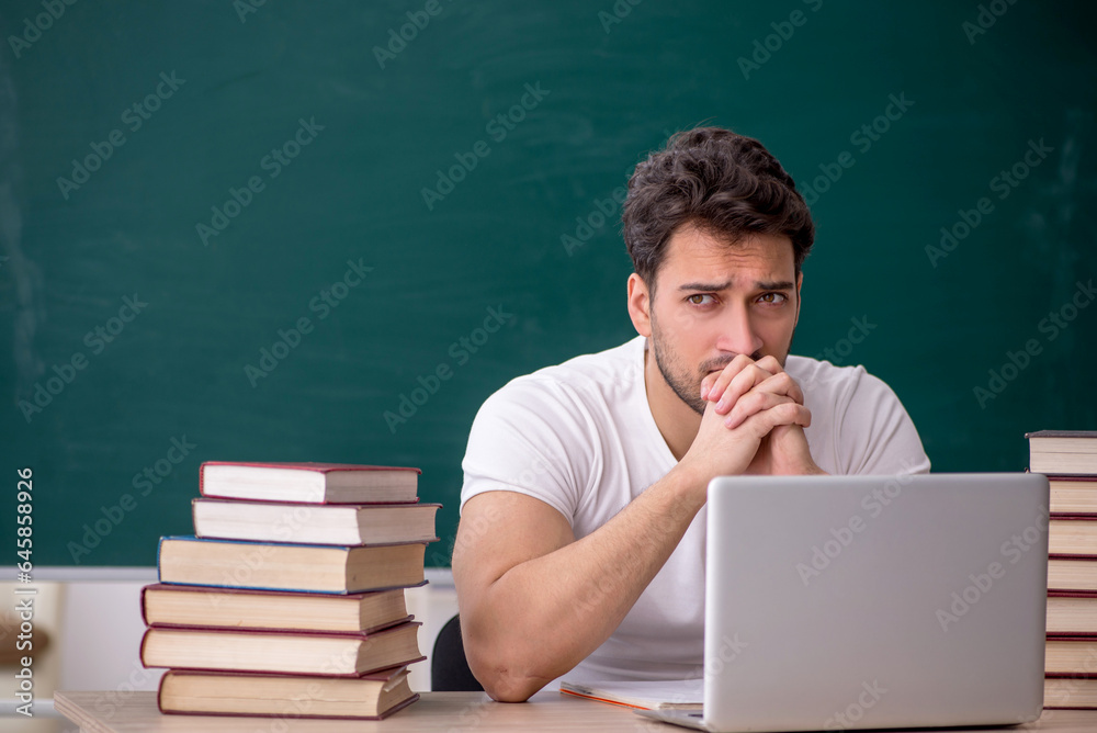 Young male student sitting in the classroom