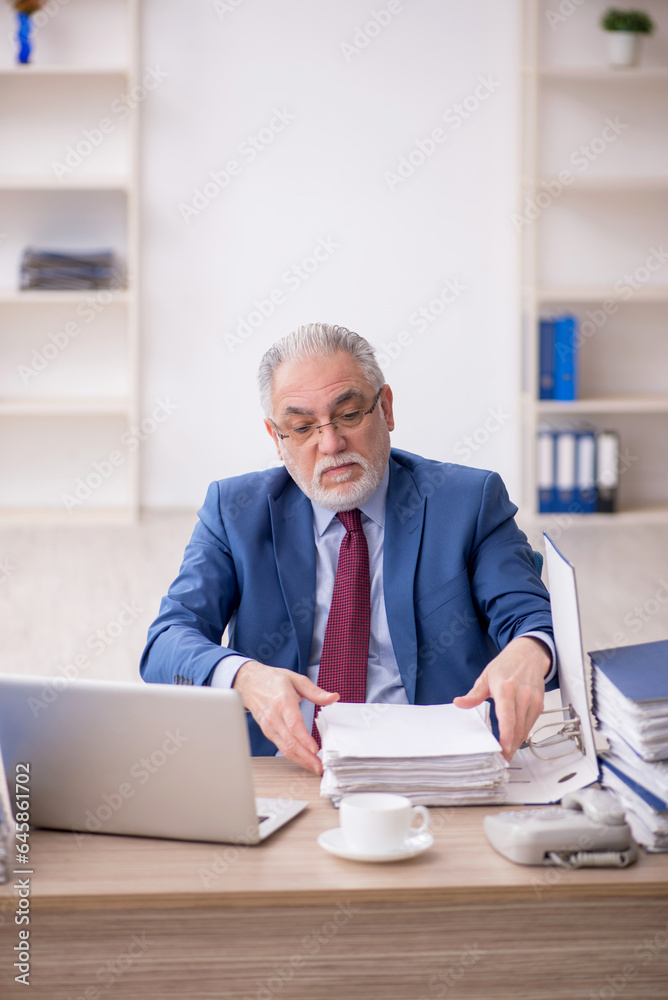 Old male employee and too much work at workplace Old male employee and too much work at workplace