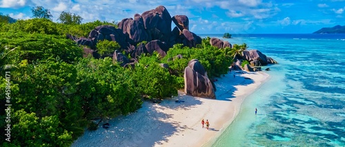 Принти на полотні Anse Source d'Argent, La Digue Seychelles, a young couple of men and women on a tropical beach during a luxury vacation in Seychelles