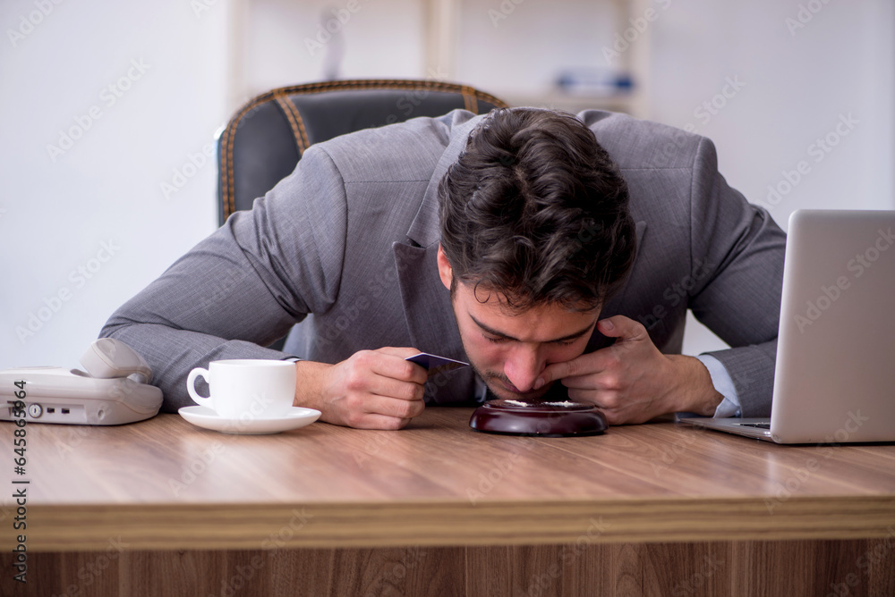Young male drug addicted employee at workplace
