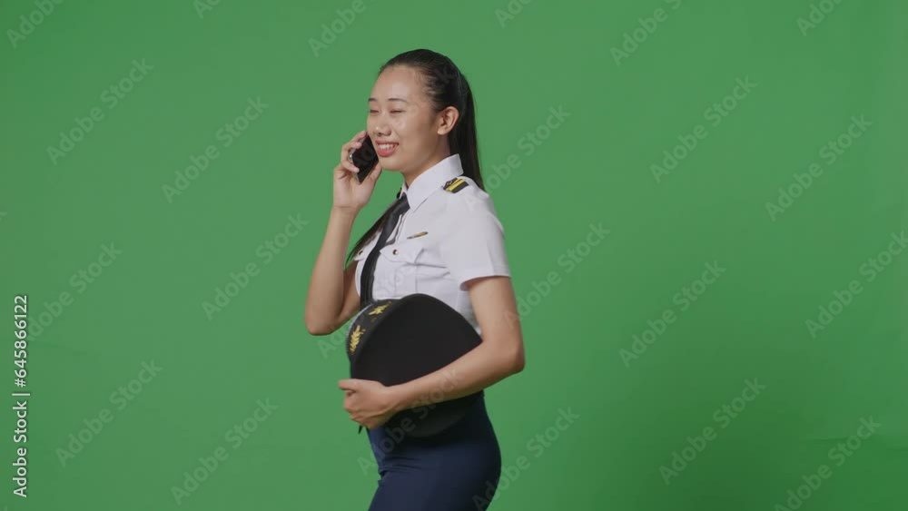 Side View Of Asian Woman Pilot Talking On Smartphone While Walking In The Green Screen Background Studio
Side View Of Asian Woman Pilot Talking On Smartphone While Walking In The Green Screen Background Studio