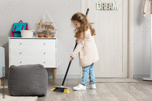 Cute little girl sweeping f...
