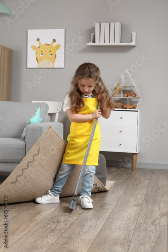 Cute little girl sweeping f...