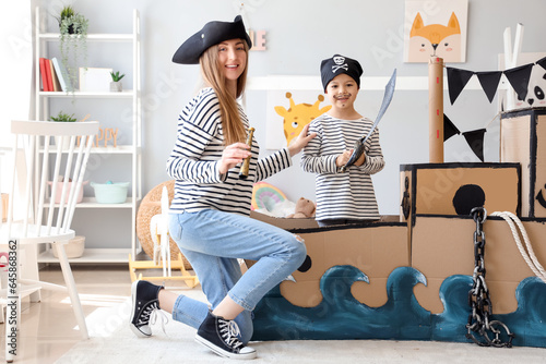 Cute little boy with his mother dressed as pirates playing at home