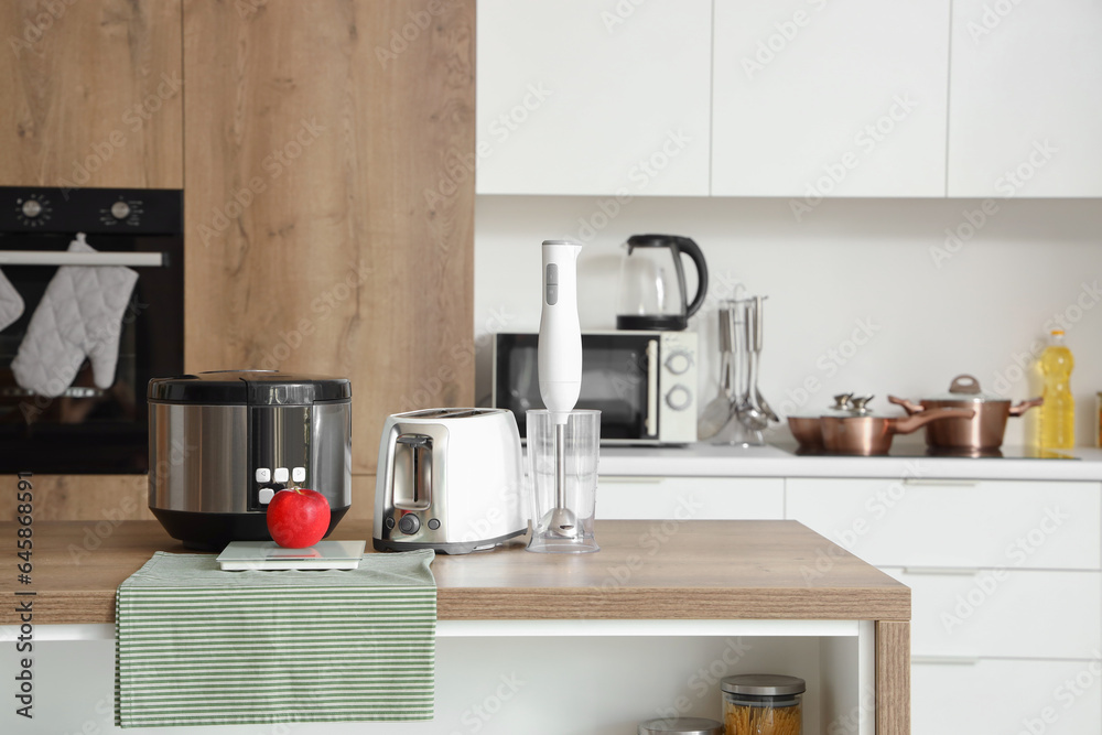 Blender, toaster, multi cooker and apple on wooden table in kitchen Blender, toaster, multi cooker and apple on wooden table in kitchen