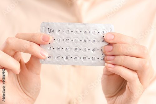 Young woman with contraceptive pills, closeup