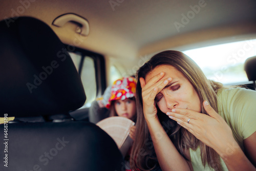 Fotografie Mom Traveling by Car Feeling Sick in the Back Seat