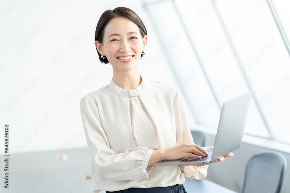笑顔でパソコンを持つ女性