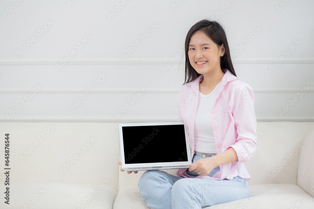 Beautiful young asian woman showing display screen mockup laptop computer with empty for advertisement, female presentation with notebook with blank for advertising, business and mock up concept. Beautiful young asian woman showing display screen mockup laptop computer with empty for advertisement, female presentation with notebook with blank for advertising, business and mock up concept.