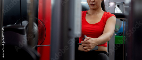 Young asian woman workout with strength training and determination with fitness gym machines, energetic asia woman exercise with motivation in fitness, sport and health, strong and flexibility.