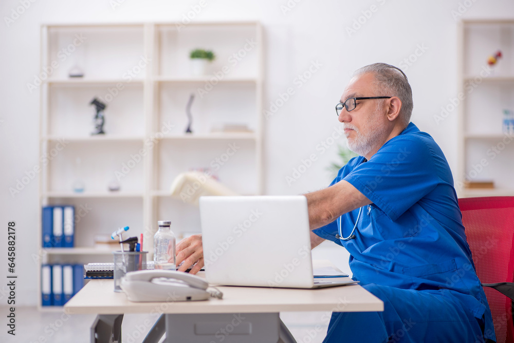 Old male doctor working in the clinic