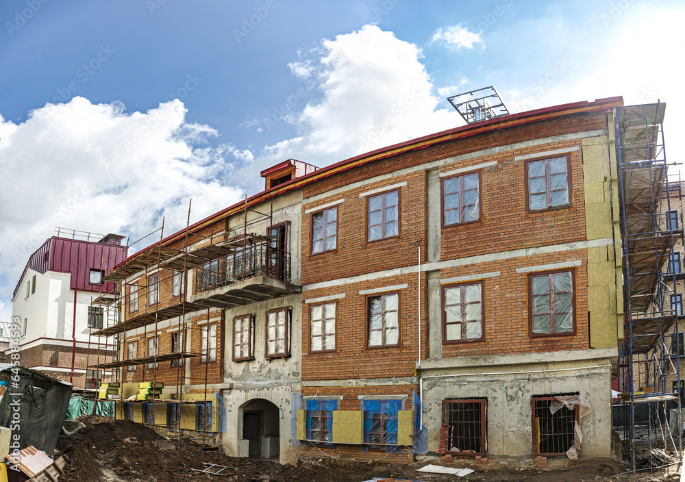 scaffolding around a building renovating facade. house reconstruction. panoramic view.