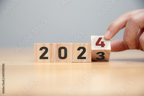 New project growth concept in 2024, Preparation for happy new year , Hand of man flip wooden cube from 2023 to 2024.