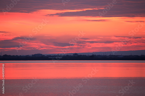 オレンジ色と雲とのグラデーションが美しい朝焼けの空 © M.Masary