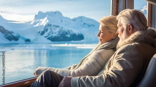 Senior couple enjoying a view from their luxurious cruise suite during admiring the majestic glaciers.