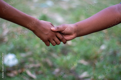 two human hands joined together in partnership and the background blur © Rokonuzzamnan