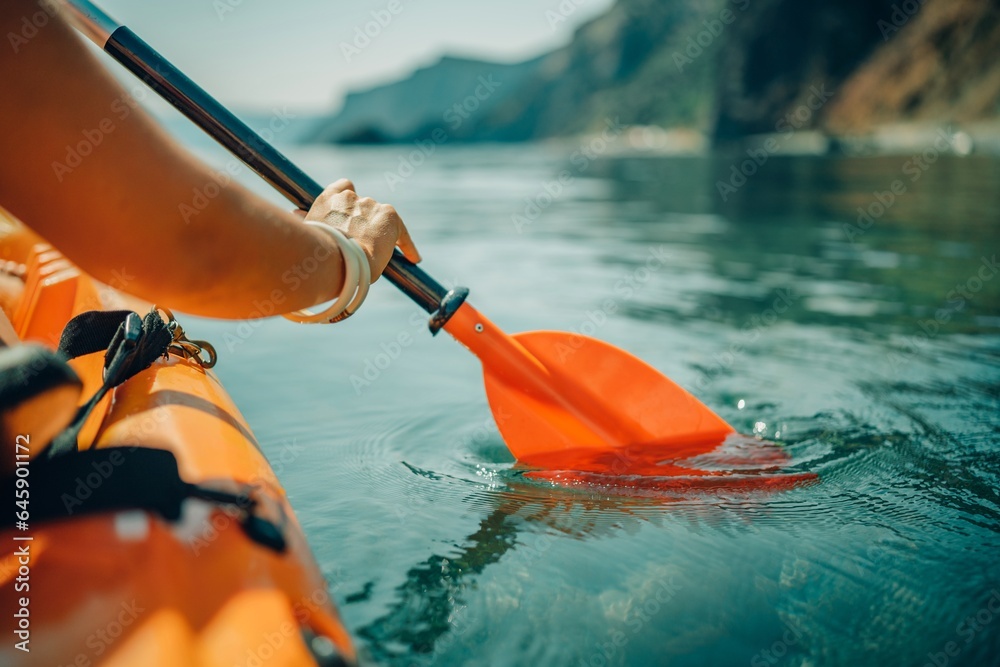 Kayak paddle sea vacation. Person paddles with orange paddle oar on kayak in sea. Leisure active lifestyle recreation activity rest tourism travel Kayak paddle sea vacation. Person paddles with orange paddle oar on kayak in sea. Leisure active lifestyle recreation activity rest tourism travel